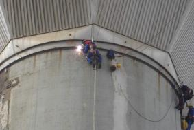 Employees using rope access in Renewable Energy industry to weld edges on water tower