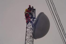 Employees using rope access on top of cellphone tower