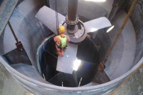 Employee hanging on rope in confined space to clean propellers for Petrochemical industry