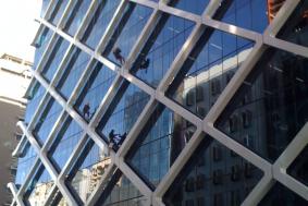 Workers hanging from outside of building to clean windows that are hard to reach