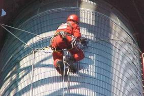 Employee in Petrochemical industry using rope access to reach outside of pipeline 