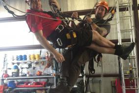Two students practicing rope access training at training facility