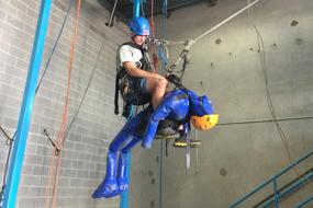 Rope access trainee suspended from ceiling with training dummie