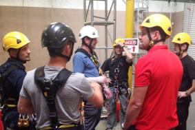Workers are huddled together for rope access training