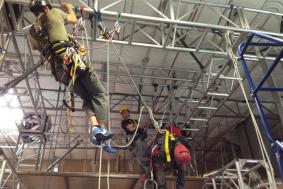 Student working with rope access technicians at a training facility